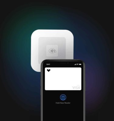 Phone displaying Starship's digital visa debit card that is next to the tap payment terminal